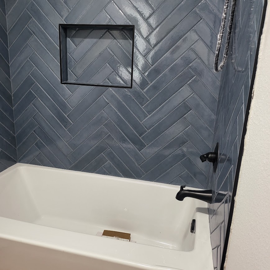Herringbone tile bathtub surround with tiled niche, completed remodel