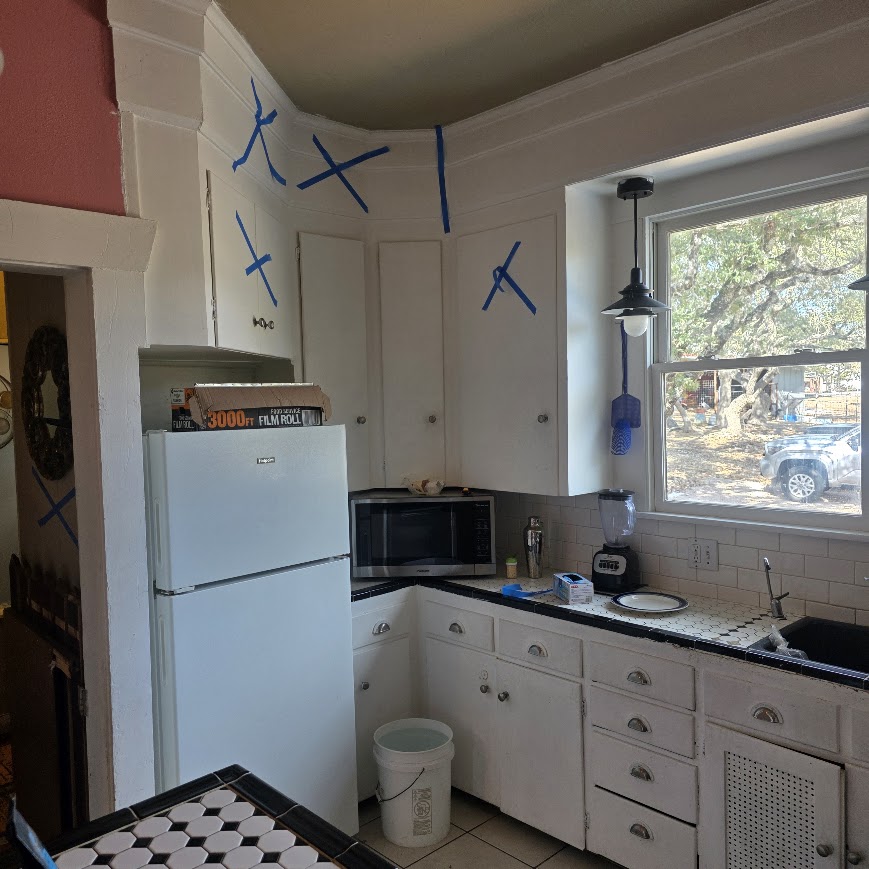 Vintage Central Texas kitchen before remodel — corner view with original white cabinets