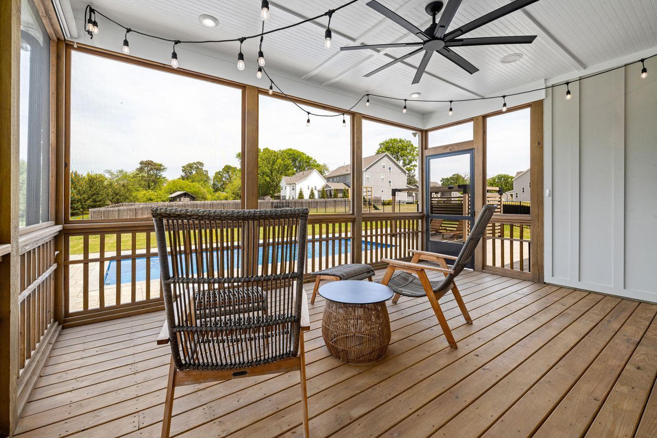 Example of a screened, covered patio with a ceiling fan overlooking a backyard pool